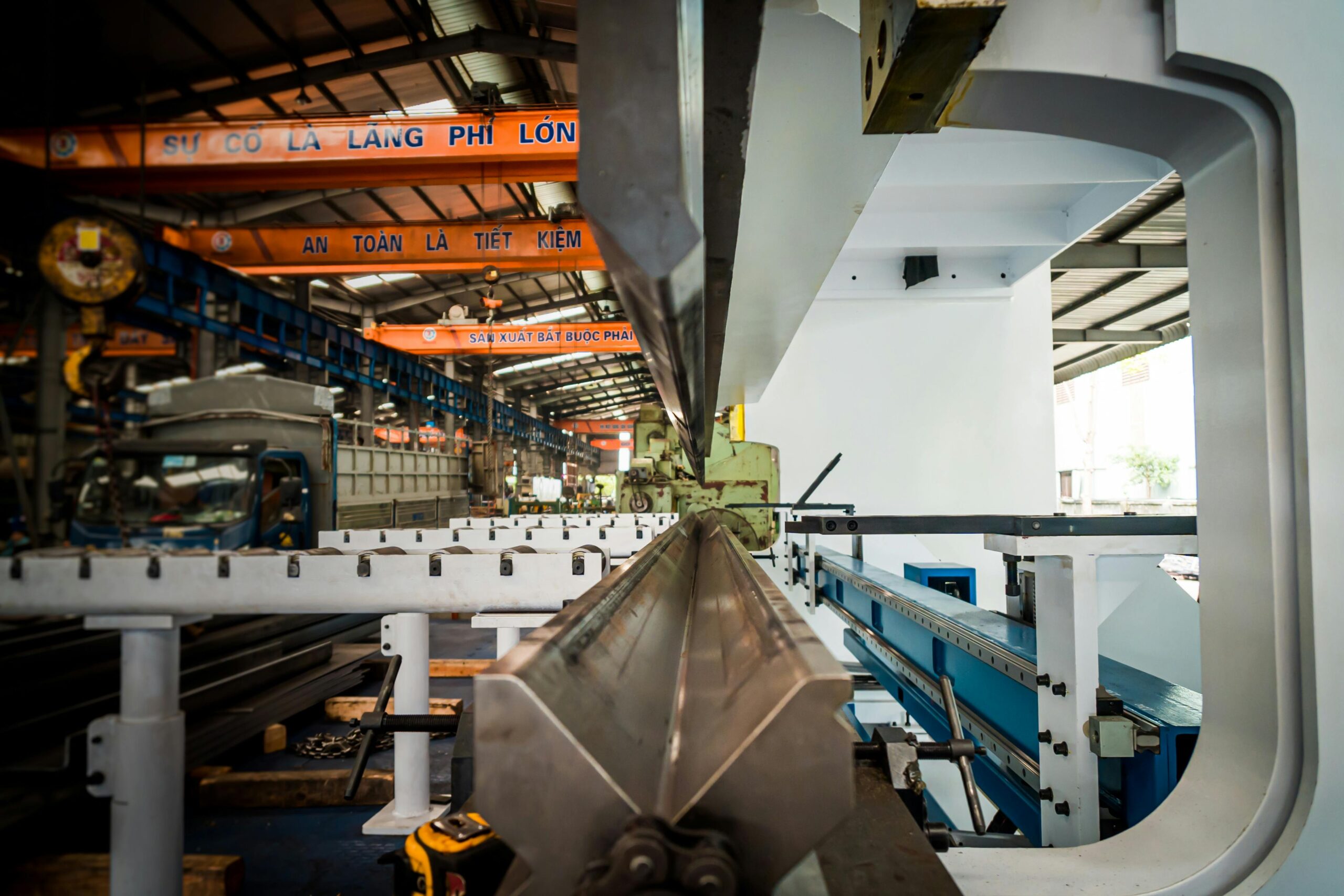 Vietnamese metal fabrication workshop viewed through a large press brake machine