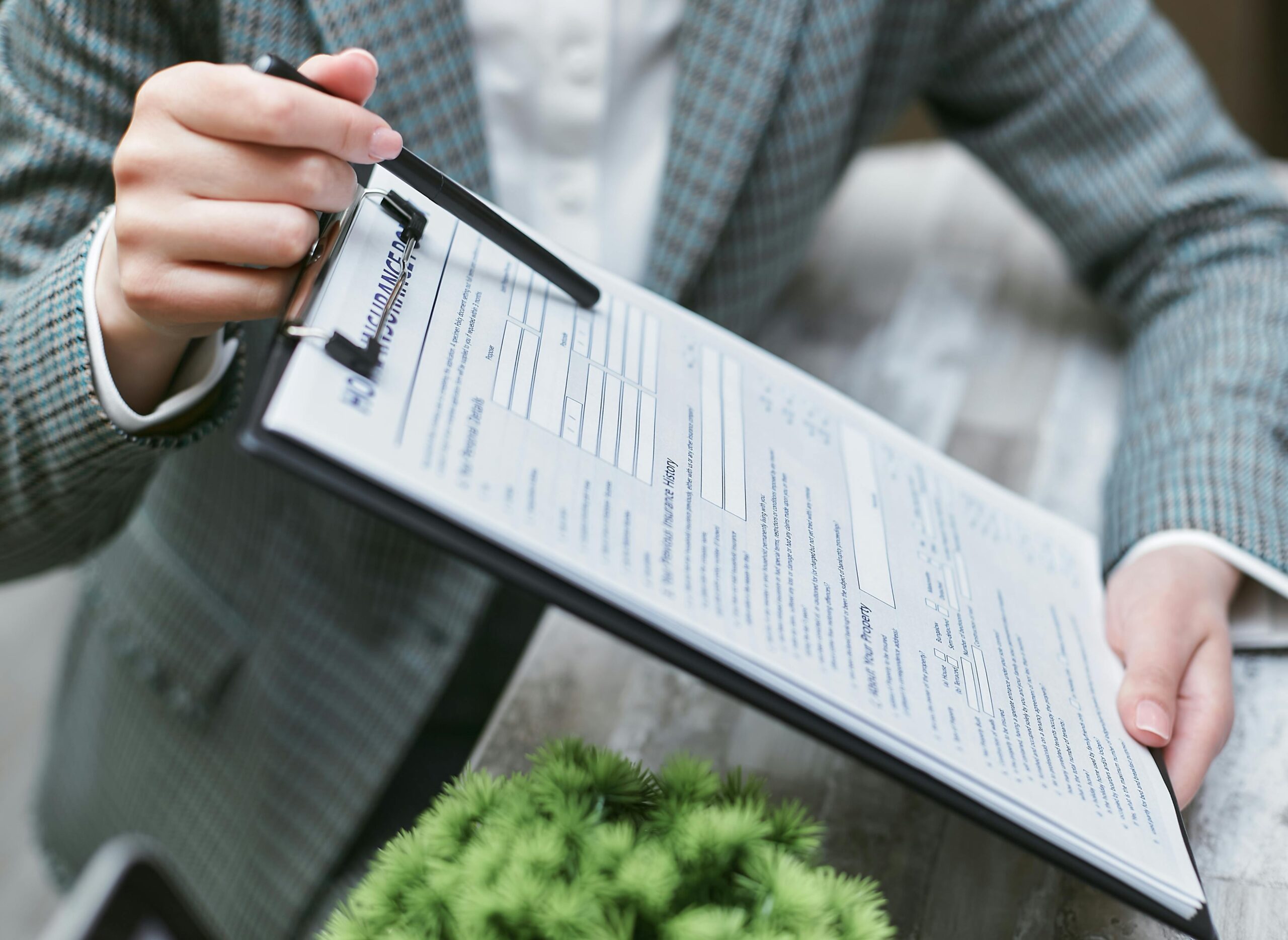 Person holding a clipboard with a printed document, reviewing requirements