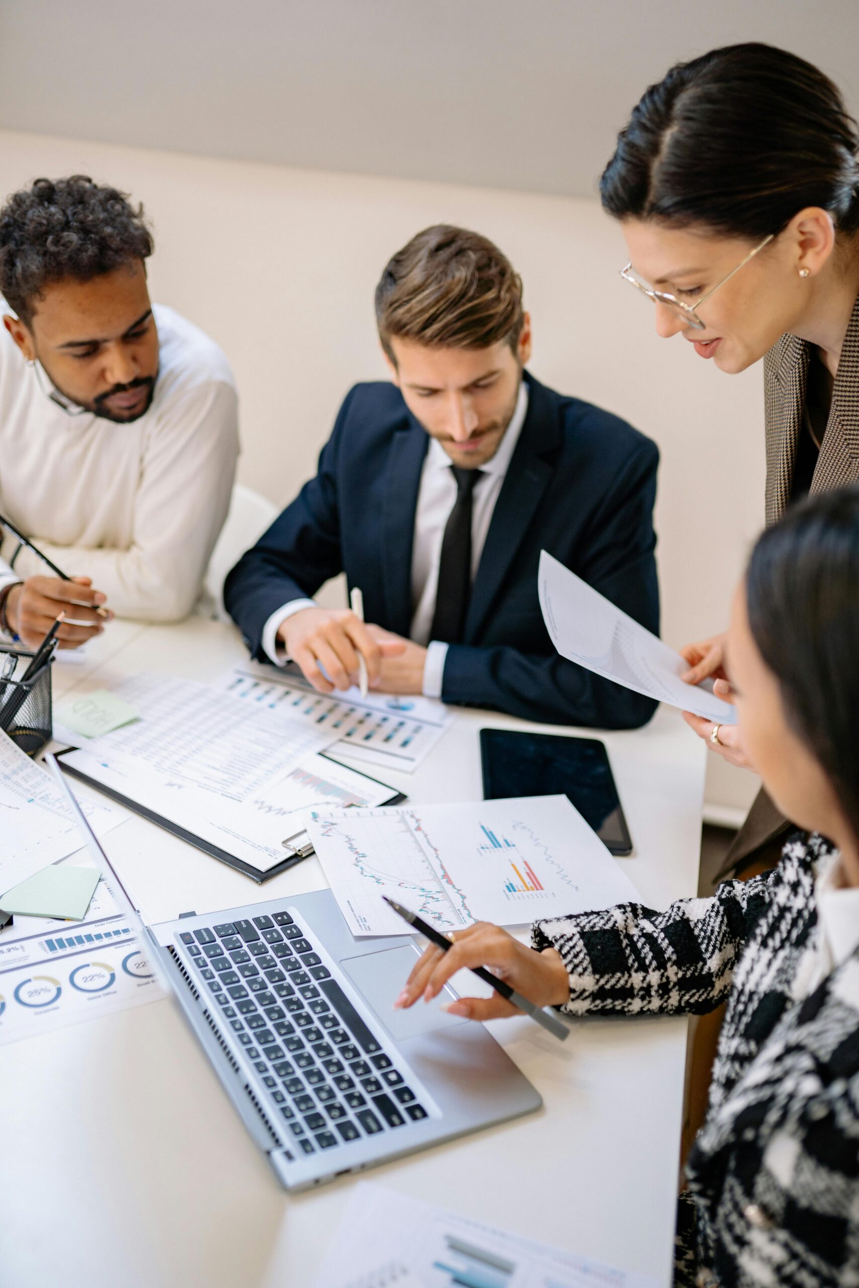 Business team reviewing charts and performance data around a conference table